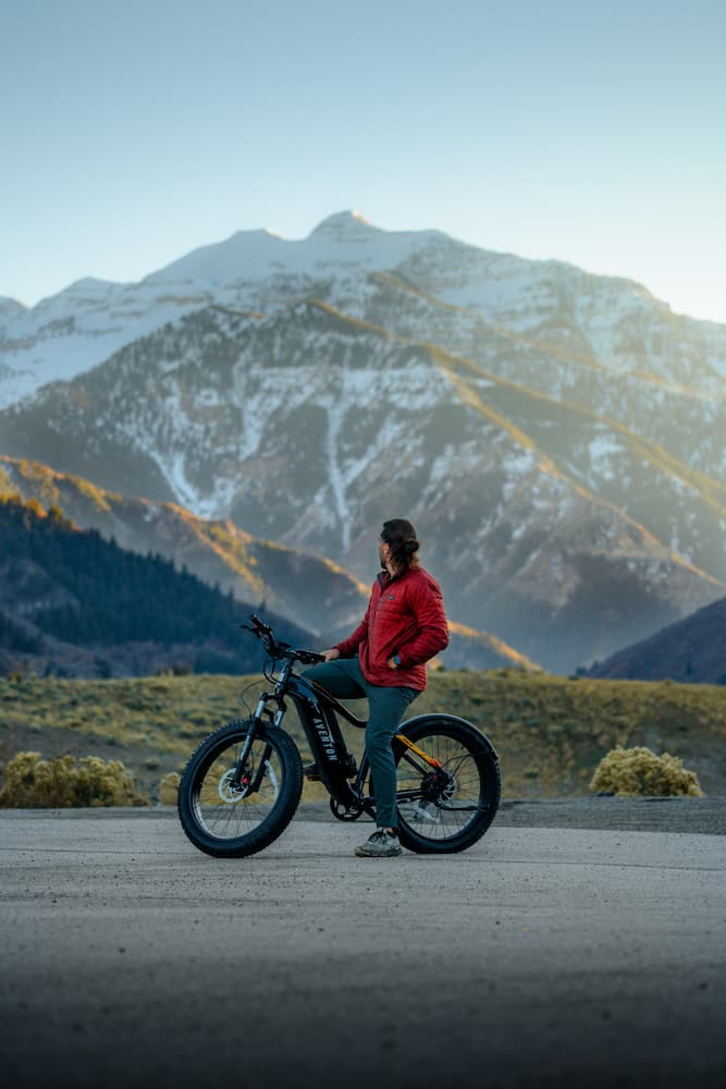 Man riding Aventon electric bicycle stops to take in mountain view